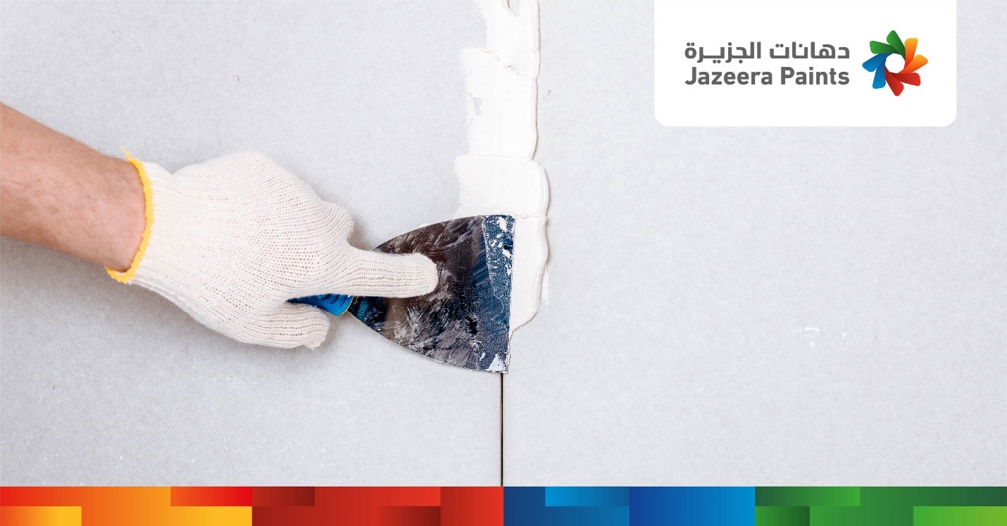 A hand in glove using a spatula to put a wall

Description automatically generated